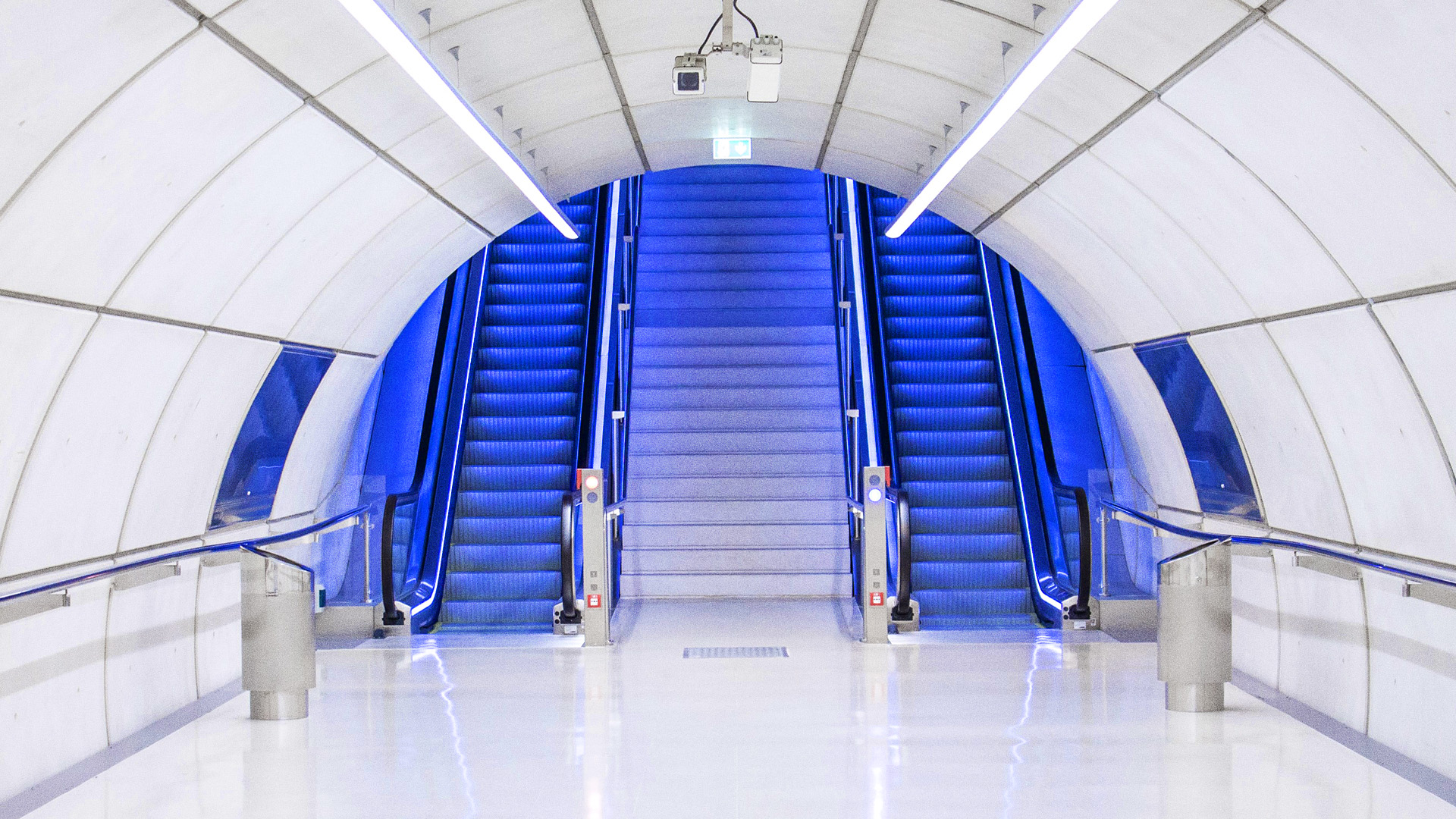 Blue escalator in a white underpass 